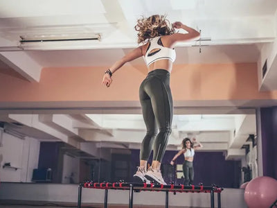woman jumping on rebounder in front of wall mirror