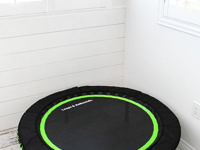 Small trampoline in a bright, white room with windows.