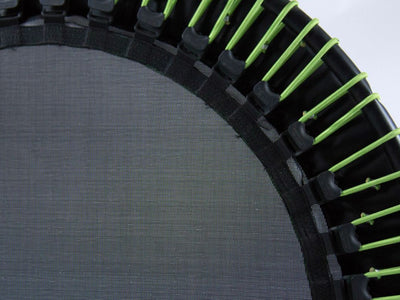 Close-up of a trampoline with green elastic bands, black frame.