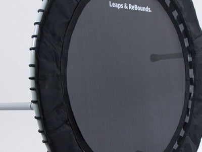 A small black exercise trampoline with three metal legs visible.