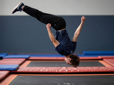 Person performing a backflip on a trampoline.