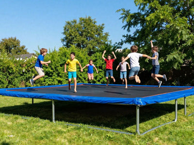 Children jumping high on a large backyard trampoline.