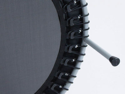 Close-up of a mini trampoline with black mat and legs.
