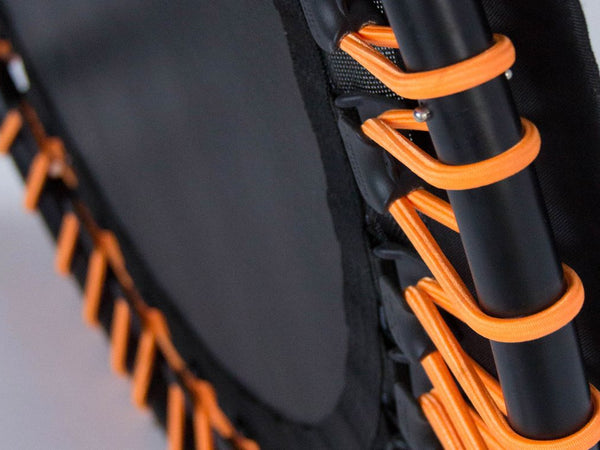 Close-up of a mini trampoline with orange elastic bands.