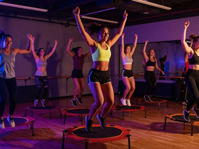 People jumping on trampolines in a fitness class.