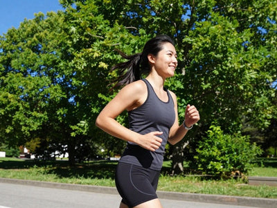 Person jogging happily outdoors in sunlight.