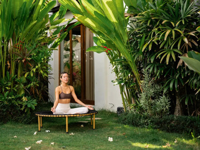 Woman sitting on rebounder in backyard.