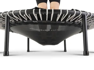 Person standing on a mini trampoline, viewed from below.