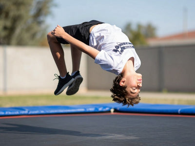 Person doing a backflip on a trampoline.