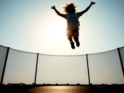Person jumping on a trampoline with joy.