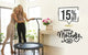 Two women playing with a trampoline in a home setting, with a Mother's Day sale promotion on the wall.