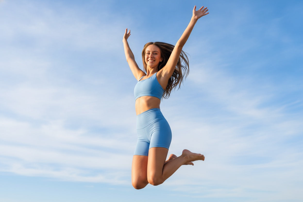 A happy woman jumping joyfully against a bright blue sky
